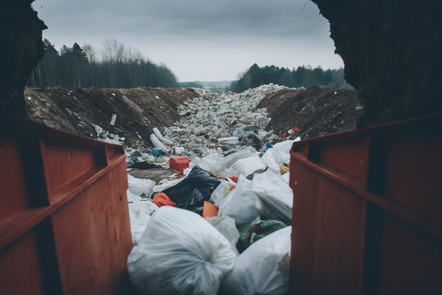 Aerial view of a massive landfill covered in discarded plastic waste stretching to the horizon